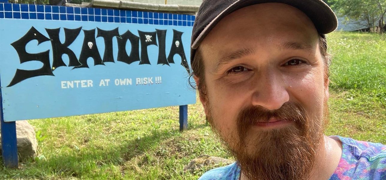 Chris Baglivo, co-owner of Jamtown, the best recording studio in philadelphia, posing infront of a Skatopia sign
